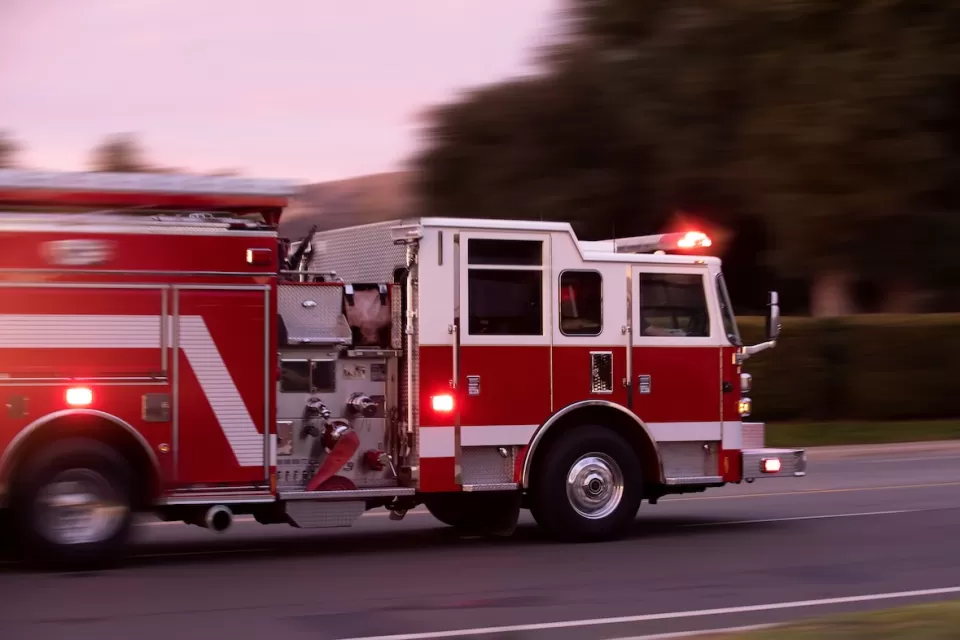 Red fire truck speeding down a street.